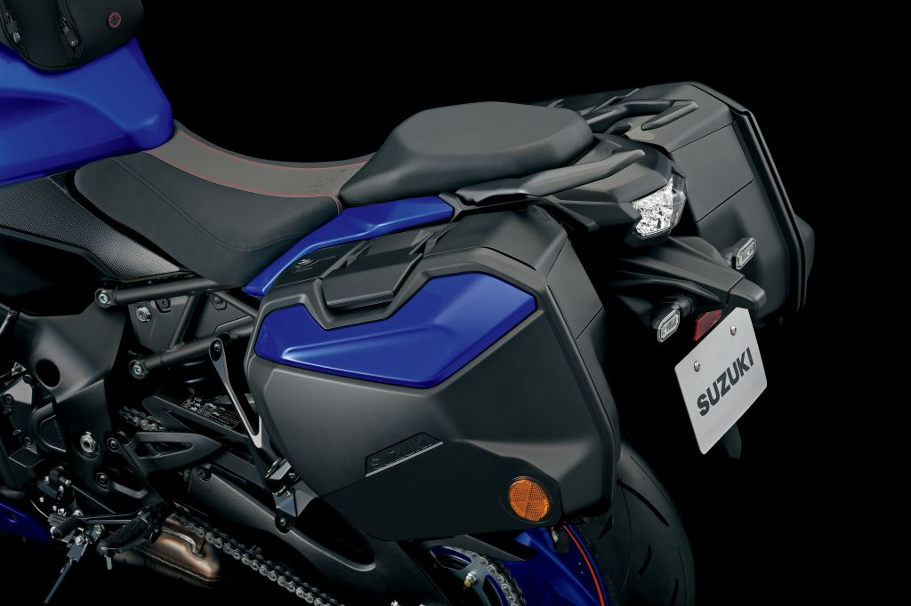 Blaue Seitenkoffer der Suzuki GSX-S1000GT, nahtlos ins Design integriert, mit reflektierenden Elementen und Suzuki-Logo auf dunklem Hintergrund