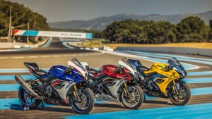 Drei Suzuki GSX-R1000R Sportmotorräder in Blau, Rot und Gelb nebeneinander auf einer Rennstrecke