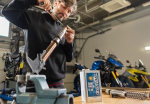 Ein Mechaniker arbeitet an einer Motorradgabel in einer Werkstatt