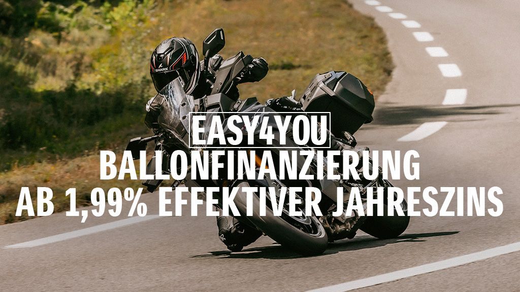 Ein Motorradfahrer auf einer schwarzen GSX-S1000GX fährt dynamisch über eine Landstraße. Im Vordergrund steht der Hinweis auf die „EASY4YOU Ballonfinanzierung ab 1,99 % effektiver Jahreszins“.