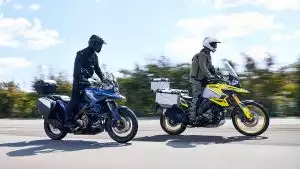 Zwei Suzuki V-Strom-Motorräder mit Fahrern und Gepäck, bereit für jede Tour als echte Allrounder.
