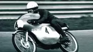 Historisches Suzuki-Rennmotorrad mit Fahrer auf Rennstrecke