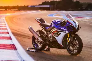Blau-weiß-rote Suzuki GSX-R125 auf Montageständer im Sonnenuntergang auf Rennstrecke.
