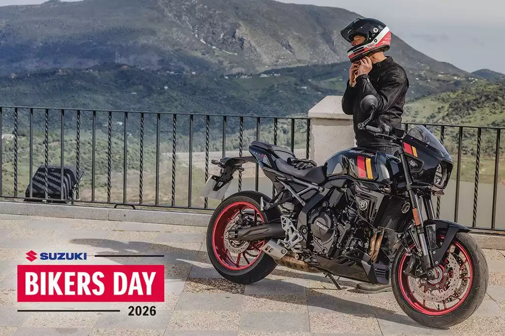 Motorradfahrer der sich gerade den Helm absetzt, macht eine Pause mit seiner schwarzen GSX-8TT bei toller Aussicht. Logo des Bikers Day 2026 zu sehen.