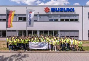 Große Gruppe von Suzuki Mitarbeitern beim Clean Ocean Project vor dem Firmengebäude.
