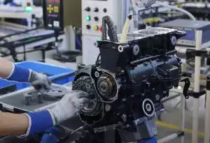 Präzise Montage eines Suzuki Motorradmotors in der Produktion, Handarbeit in der Fertigungshalle.