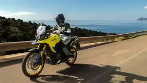 Motorradfahrer auf Suzuki Adventure-Bike entlang einer Küstenstraße mit Meerblick