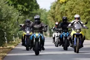 Gruppe von Motorradfahrern auf Suzuki-Motorrädern bei einer Ausfahrt auf einer Landstraße.