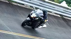 Motorradfahrer auf Suzuki-Motorrad in Kurve auf Rennstrecke.