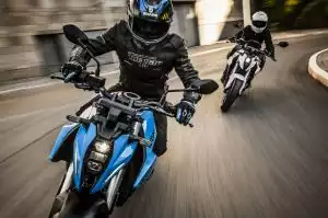 Zwei Suzuki Bikes mit Fahrern in voller Fahrt in einer Kurve.