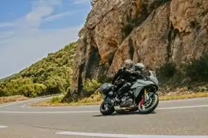 Zwei Motorradfahrer auf einer Suzuki auf kurviger Straße in Frankreich
