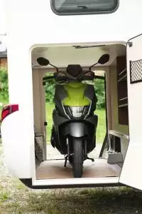 Frontansicht vom grünen Suzuki Avenis Roller im Wohnmobil, praktischer Begleiter für Camping und Reisen.
