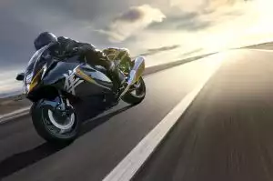 Motorradfahrer auf Suzuki Hayabusa bei Sonnenuntergang auf offener Straße