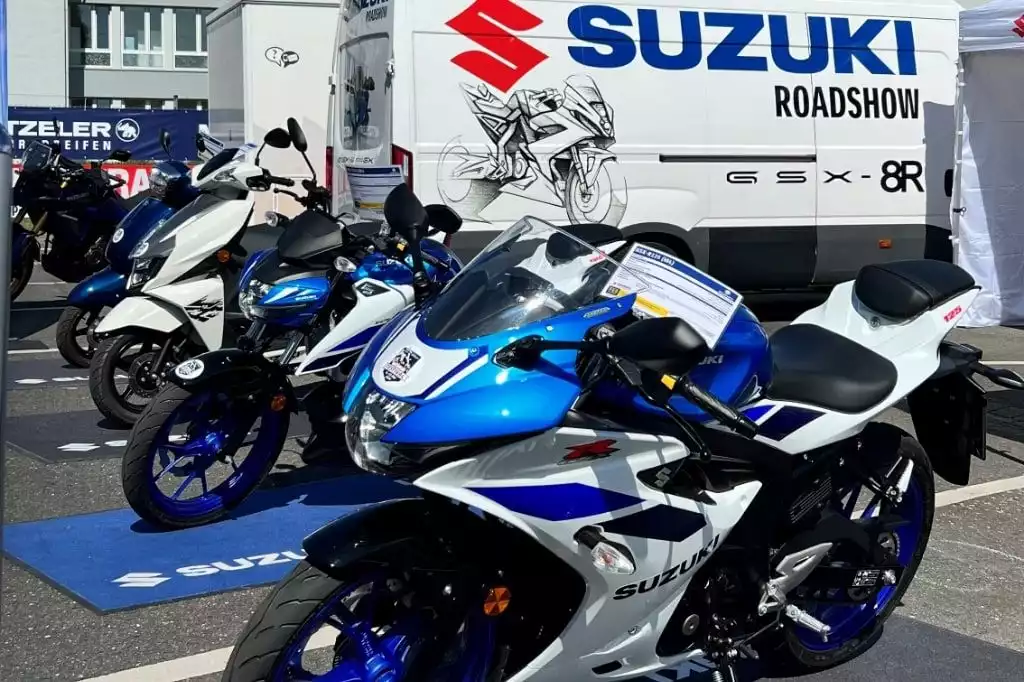 Reihe von Suzuki Motorrädern bei einer Roadshow-Veranstaltung im Freien