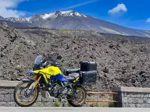 Gelbes Suzuki Adventure-Motorrad vor Vulkanlandschaft.
