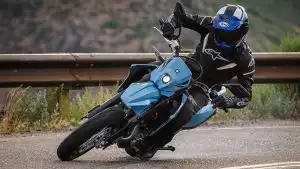 Motorradfahrer auf Suzuki Supermoto in starker Schräglage in einer Kurve.