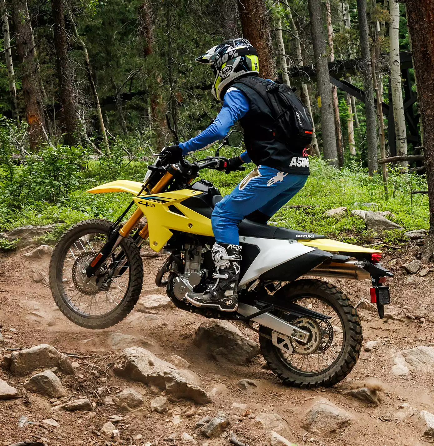 Gelbes Suzuki DR-Z4S Motorrad im Gelände mit Fahrer in blauer Schutzkleidung