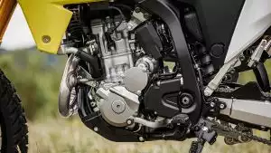 Motor des Suzuki DR-Z4S Motorrads in Nahaufnahme auf einer Wiese.