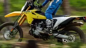 Fahrer auf gelber Suzuki DR-Z400SM in Bewegung, zeigt dynamische Fahrt und Designmerkmale der Supermoto.