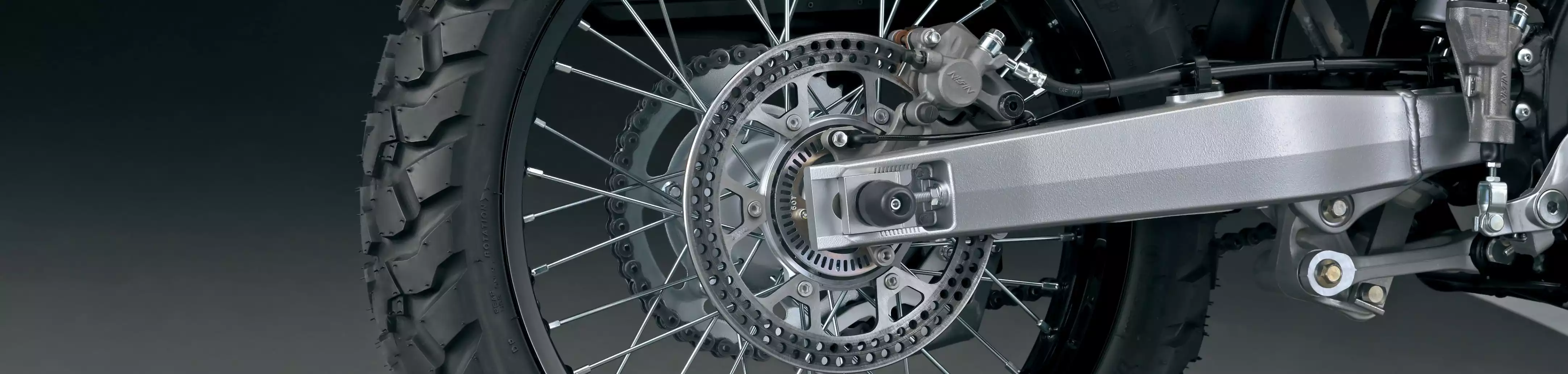 Hinterrad des Suzuki DR-Z4S Motorrads mit silbernem Achsprotektor und Bremsscheibenabdeckung