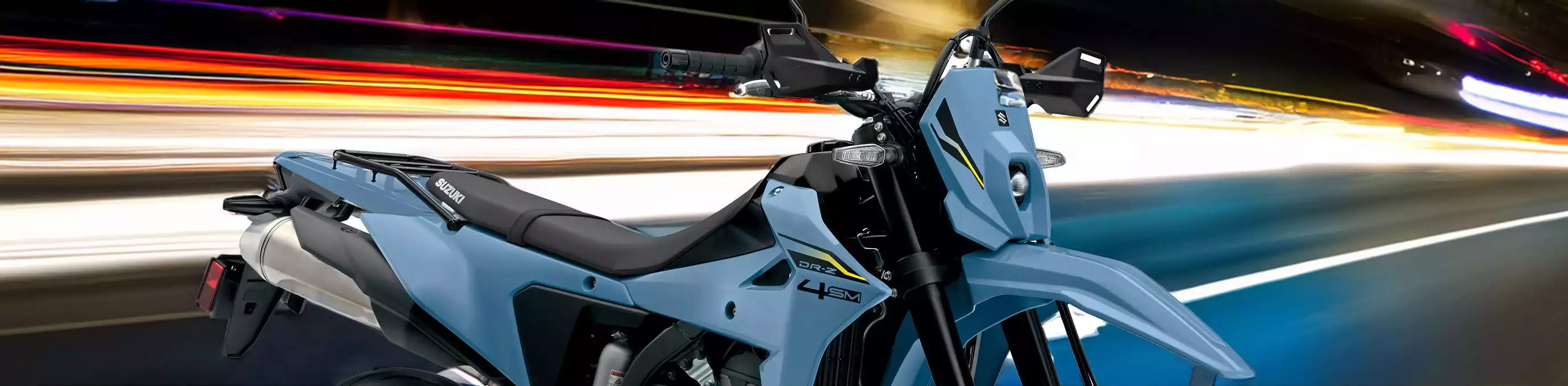 Suzuki Motorrad DR-Z4S in Blau bei Nachtfahrt auf beleuchteter Straße
