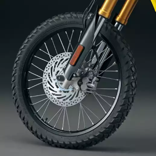 Vorderrad des Suzuki DR-Z4S Motorrads mit Achsprotektor und Bremsscheibenabdeckung.
