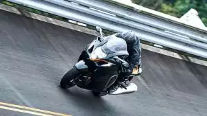 Schwarze Suzuki Hayabusa mit Fahrer in dynamischer Schräglage bei Kurvenfahrt auf der Rennstrecke.