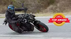 Schwarze Suzuki GSX-8S in Schräglage auf Landstraße, mit goldenem Top Award Logo ausgezeichnet.