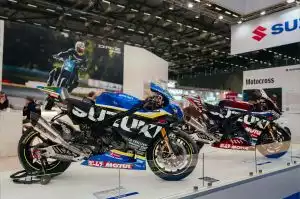 Zwei Suzuki GSX-R Rennmotorräder in Blau und Rot auf dem Messestand der Intermot 2024 präsentiert.