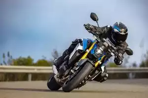 Dynamische Kurvenfahrt der Suzuki GSX-S1000 auf einer Gebirgsstraße, Fahrer in tiefer Schräglage.
