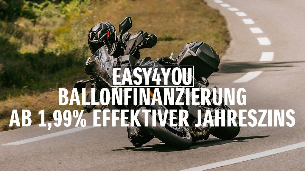 Ein Motorradfahrer auf einer schwarzen GSX-S1000GX fährt dynamisch über eine Landstraße. Im Vordergrund steht der Hinweis auf die „EASY4YOU Ballonfinanzierung ab 1,99 % effektiver Jahreszins“.