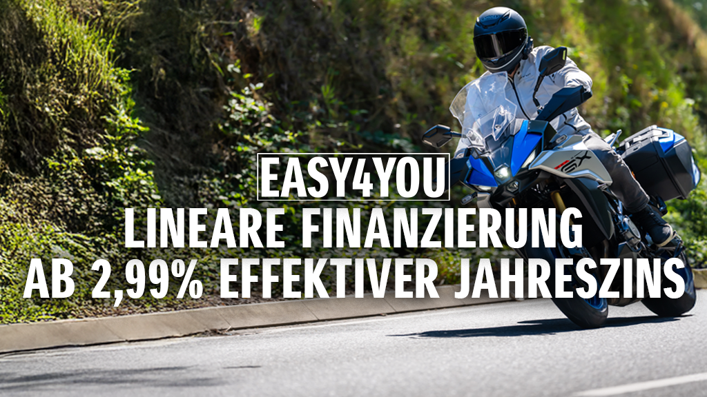 Ein Motorradfahrer auf einer Suzuki GSX-S1000GX fährt eine sonnige Landstraße entlang. Im Vordergrund wird die EASY4YOU lineare Finanzierung mit 2,99 % effektivem Jahreszins beworben.