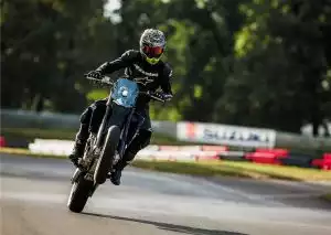 Fahrer auf blauer Suzuki DR-Z400SM Supermoto in dynamischer Fahrt auf der Rennstrecke.