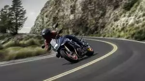Suzuki Motorradfahrer in tiefer Schräglage auf einem Naked Bike in einer Bergkurve.