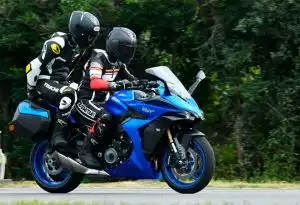 Zwei Motorradfahrer auf einer blauen Suzuki GSX-S1000GT auf einer Landstraße