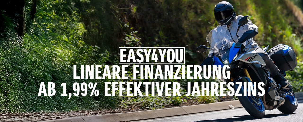 Ein Motorradfahrer auf einer Suzuki GSX-S1000GX fährt eine sonnige Landstraße entlang. Im Vordergrund wird die EASY4YOU lineare Finanzierung mit 1,99 % effektivem Jahreszins beworben.