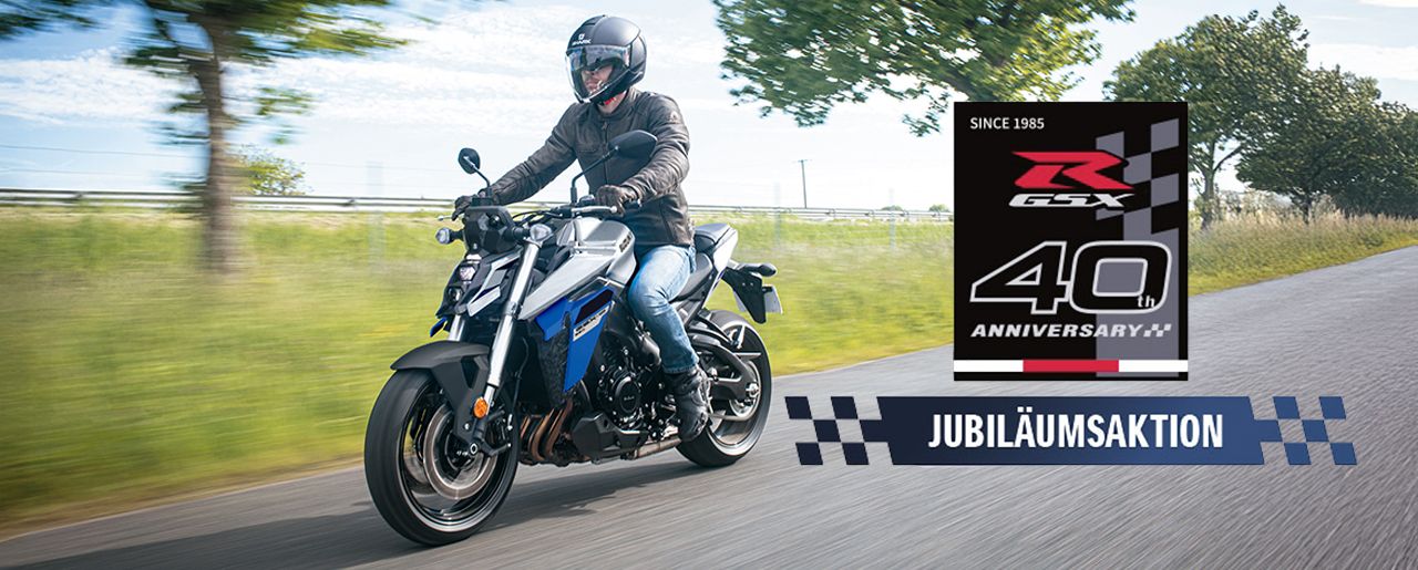 Eine blaue GSX-S950 auf einer Landstraße, rechts unten mit Jubiläumsaktions-Logo