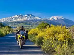 Ein Suzuki Motorrad, im Hintergrund ein schneebedecktes Gebirge