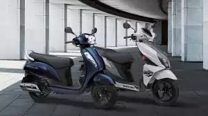 Zwei Suzuki Motorroller in modernem städtischen Umfeld