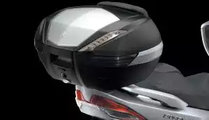 Schwarzer Suzuki Motorradkoffer auf einem silbernen Roller montiert