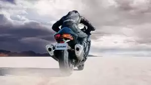Motorradfahrer auf Suzuki-Motorrad in dynamischer Wüstenlandschaft