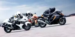 Drei Suzuki Motorräder in voller Fahrt auf einer Rennstrecke