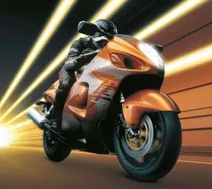 Orange Suzuki Hayabusa Motorrad in Bewegung mit Lichteffekten im Hintergrund