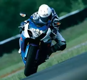 Motorradfahrer auf Suzuki Supersport-Motorrad in Kurvenlage auf Rennstrecke