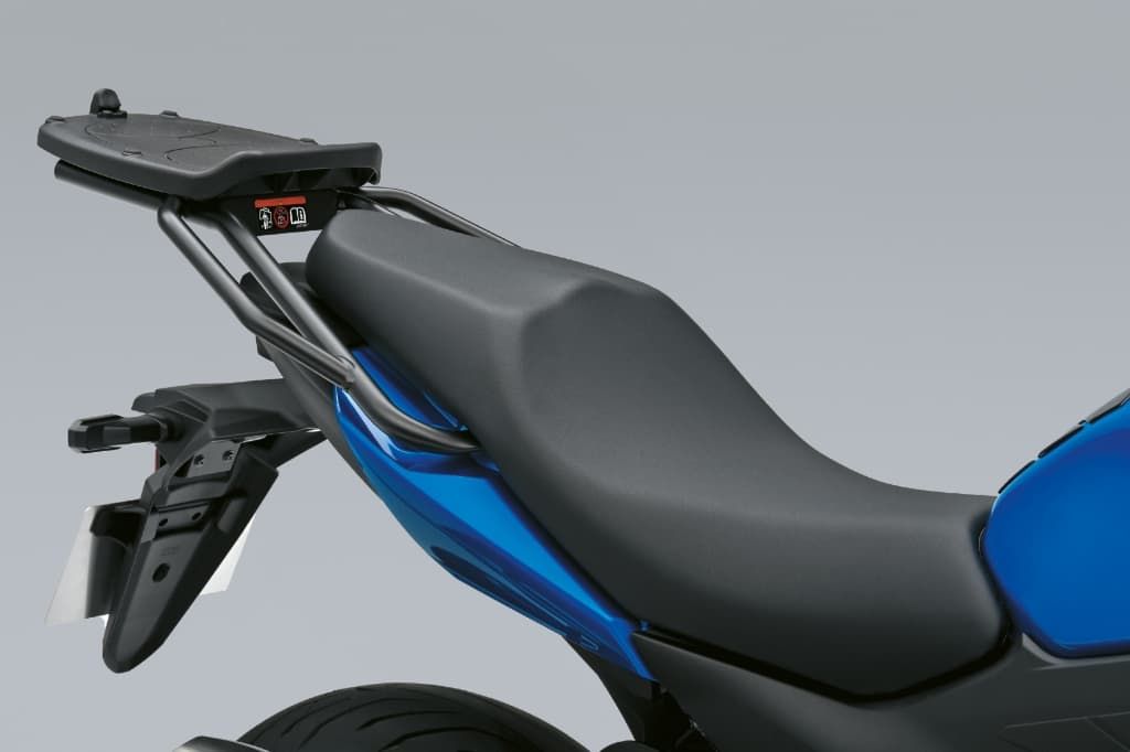 Komforthöherer Sitz einer Suzuki in Seitenansicht; schwarze, ergonomisch geformte Sitzbank mit blauem Fahrzeugheck darunter.