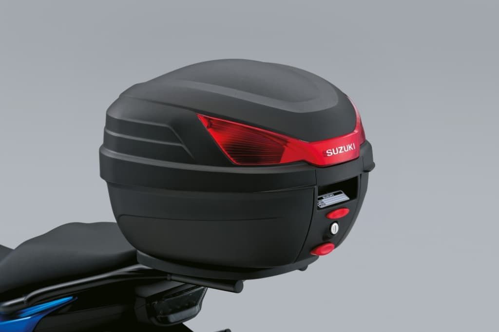 Schwarzes 27-Liter-Topcase von Suzuki, montiert am Motorradheck; rote Reflektoren auf der Rückseite.