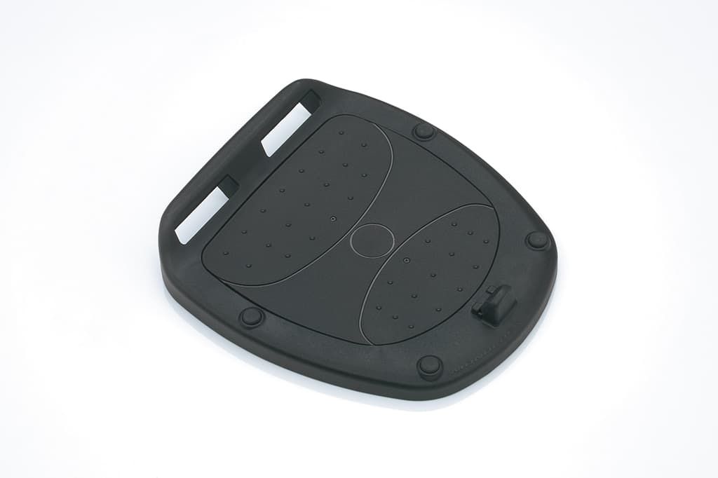 Schwarze Adapterplatte für ein Topcase des Suzuki e-Address, auf hellem Hintergrund liegend; sichtbar sind Befestigungspunkte und strukturierte Oberfläche.