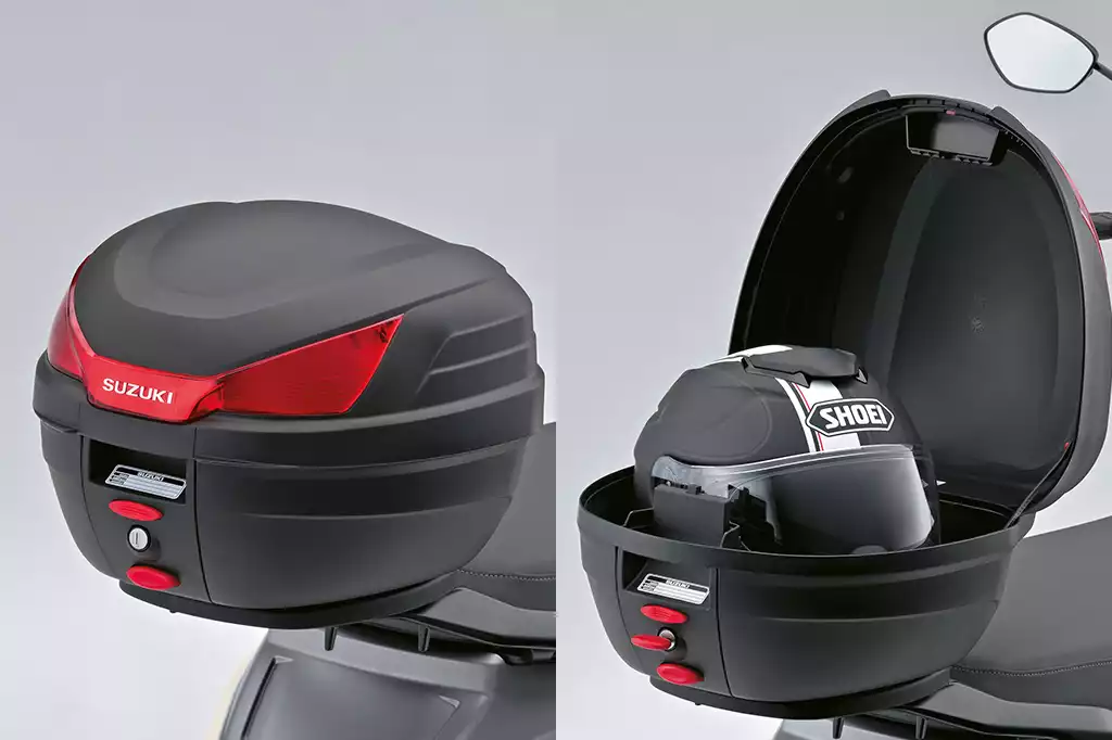 Kunststoff Top Case (27L) für Suzuki e-Address, links geschlossen, rechts offen mit Helm, bietet kompakten Stauraum.