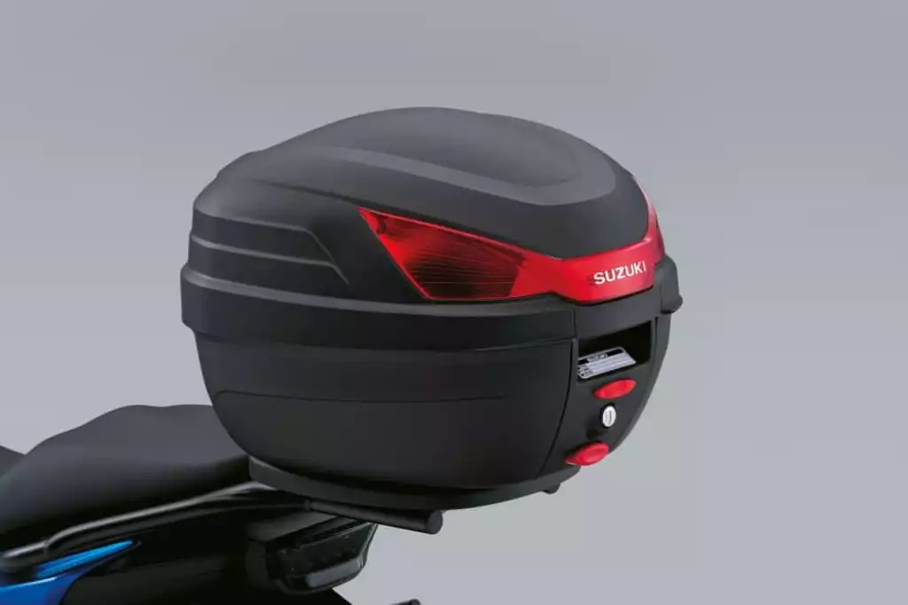 Schwarzes 27-Liter-Topcase von Suzuki, montiert am Motorradheck; rote Reflektoren auf der Rückseite.