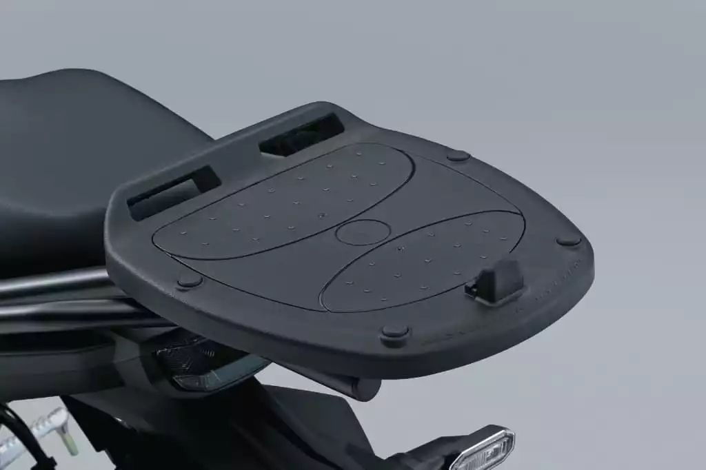 Schwarze Topcase-Adapterplatte für Suzuki SV-7GX, montiert hinter der Sitzbank mit Befestigungspunkten.